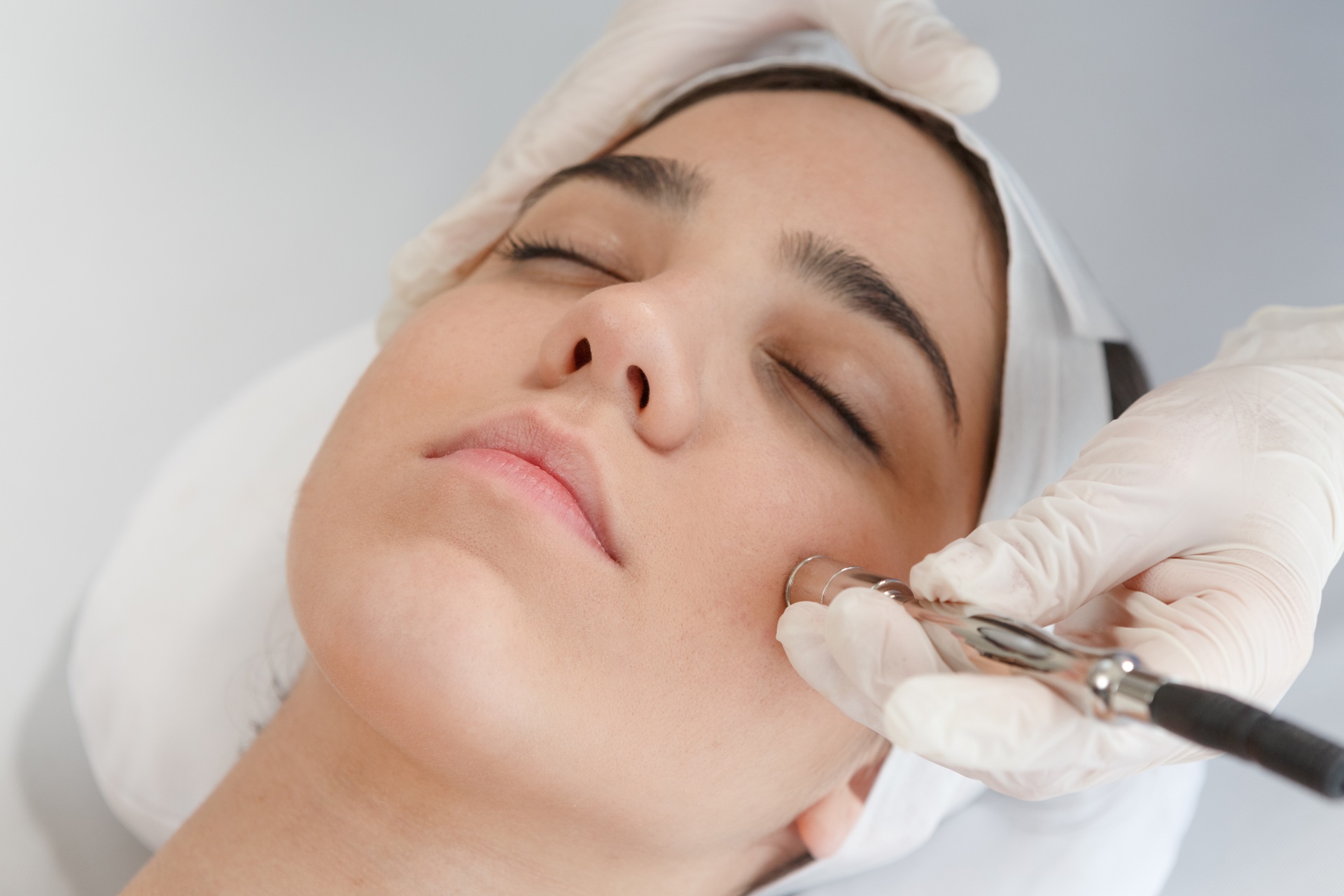 Especialista realizando limpieza facial profunda con microdermoabrasión en cabina